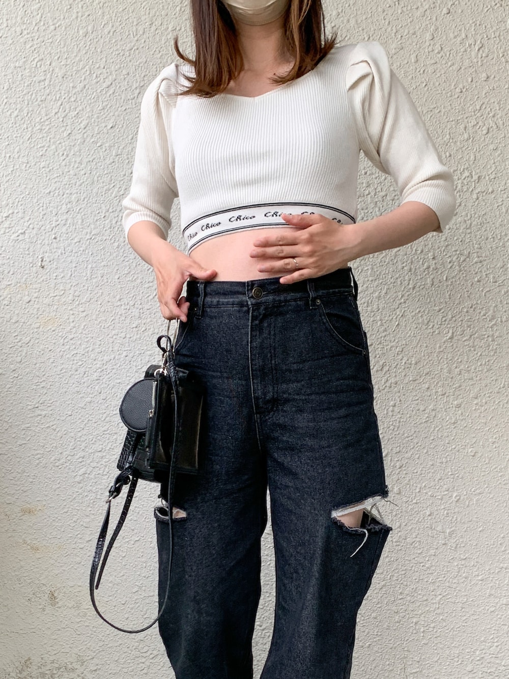 ホワイト系のニット/セーター、ブラック系のデニムパンツ、ブルー系のパンプスを着用したレディースの春コーディネートの5枚目の写真