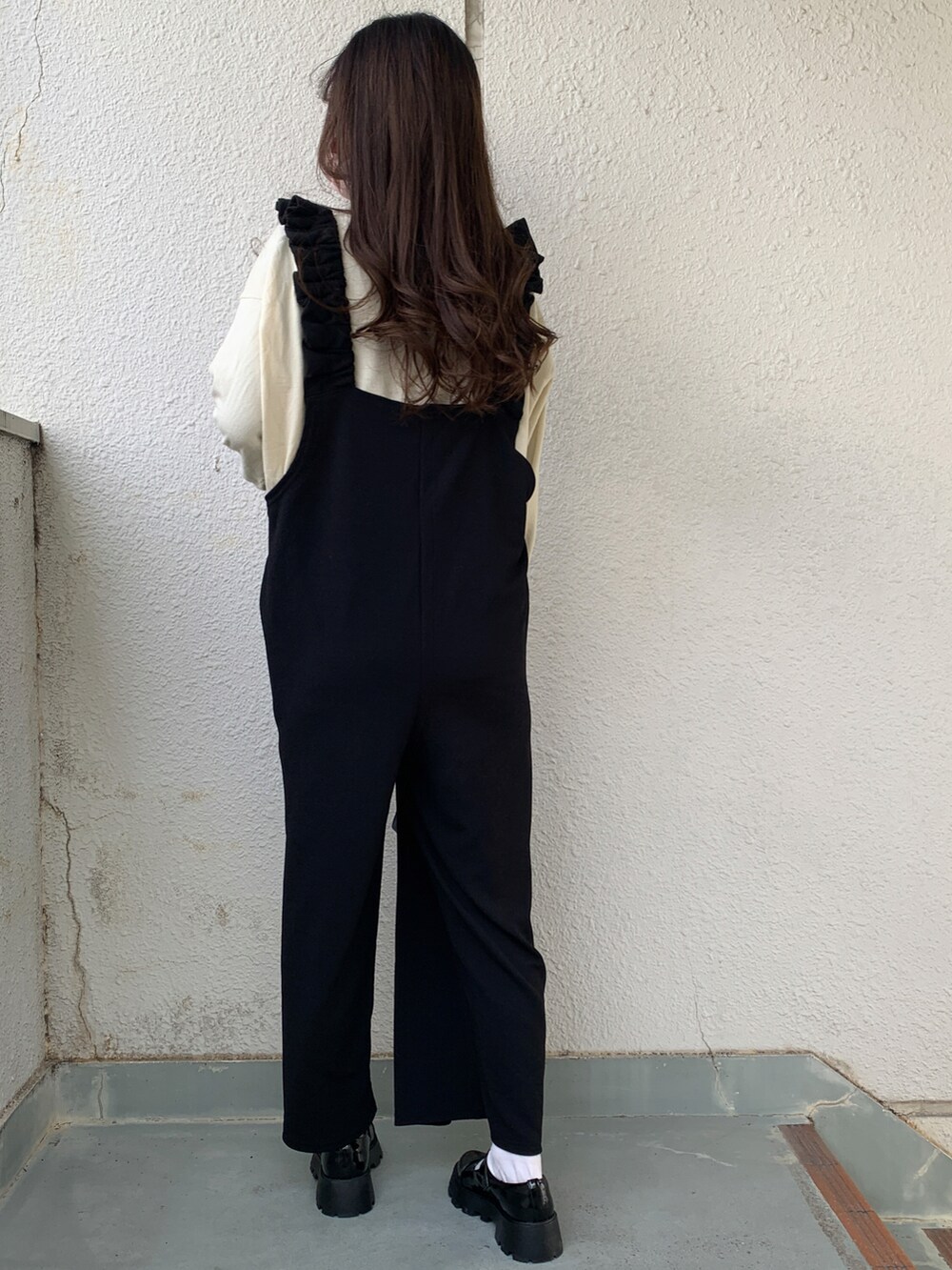 ブラック系のドレスシューズ、ホワイト系のノーカラーコート、ホワイト系のストール/ショールを着用したレディースの冬コーディネートの2枚目の写真