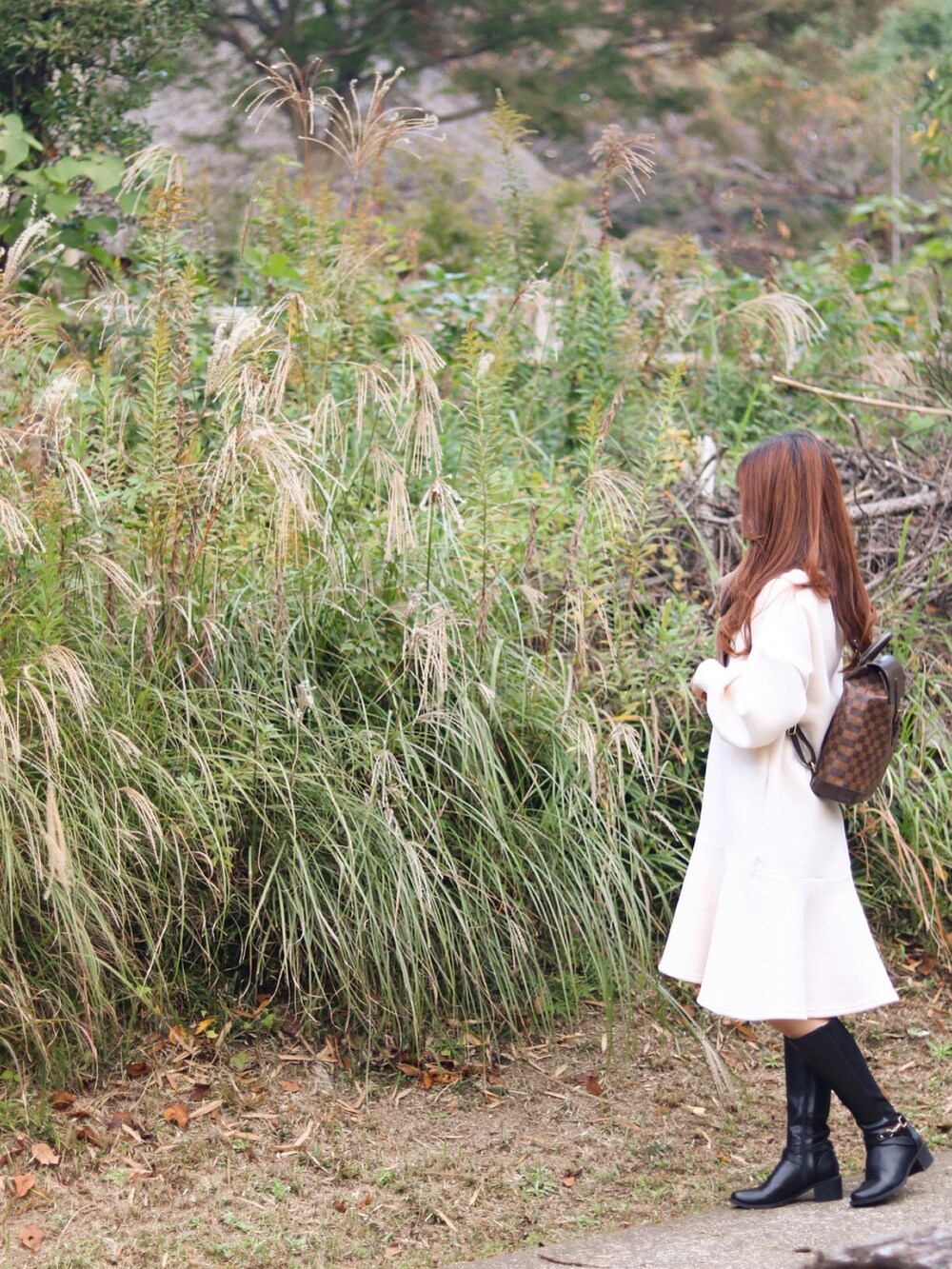 ブラック系のブーツ、ブラウン系のマフラーを着用したレディースの秋コーディネートの2枚目の写真