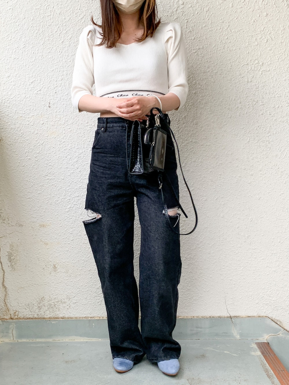 ホワイト系のニット/セーター、ブラック系のデニムパンツ、ブルー系のパンプスを着用したレディースの春コーディネートの2枚目の写真