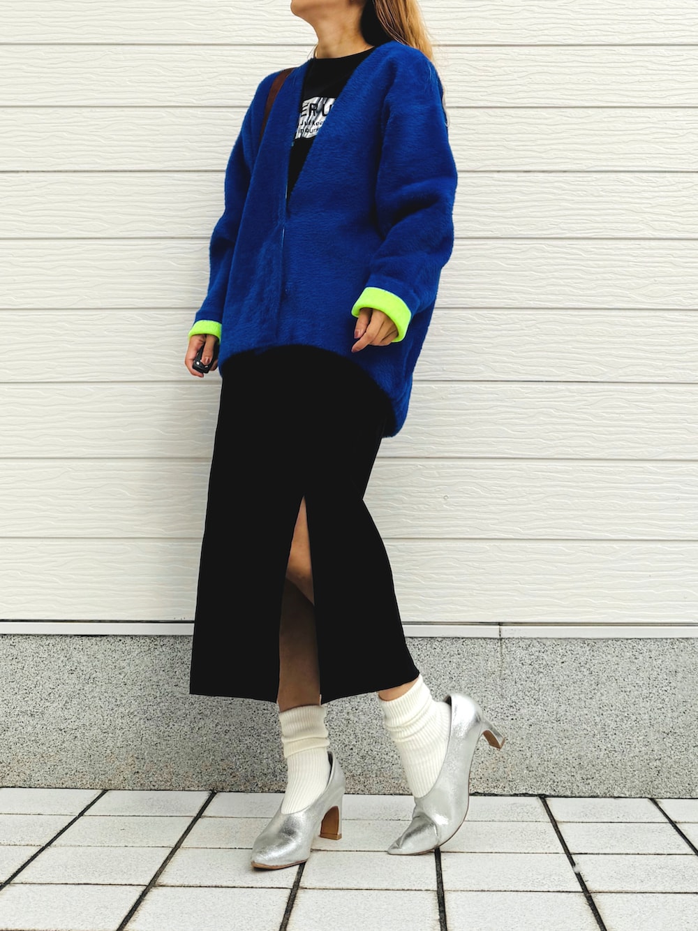 ブラック系のスカート、ブルー系のカーディガン/ボレロ、ブラック系のTシャツ/カットソーを着用したレディースの秋コーディネートの2枚目の写真