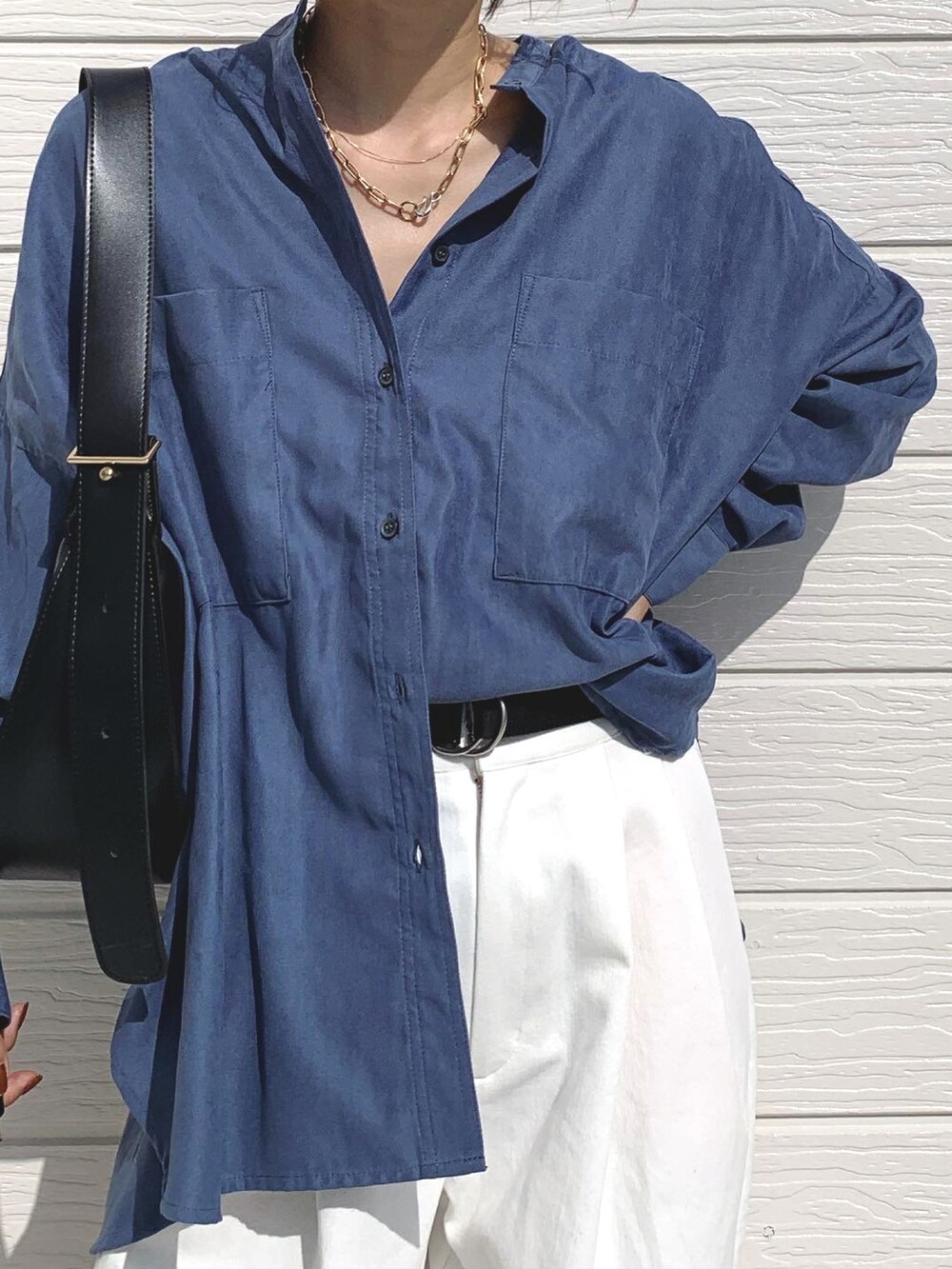 ホワイト系のデニムパンツ、ブルー系のシャツ/ブラウス、ブラック系のスニーカーを着用したレディースの秋コーディネートの2枚目の写真