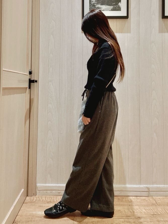 ブラック系のニット/セーター、ブラック系のその他パンツ、ブルー系のショルダーバッグを着用したレディースの冬コーディネートの2枚目の写真