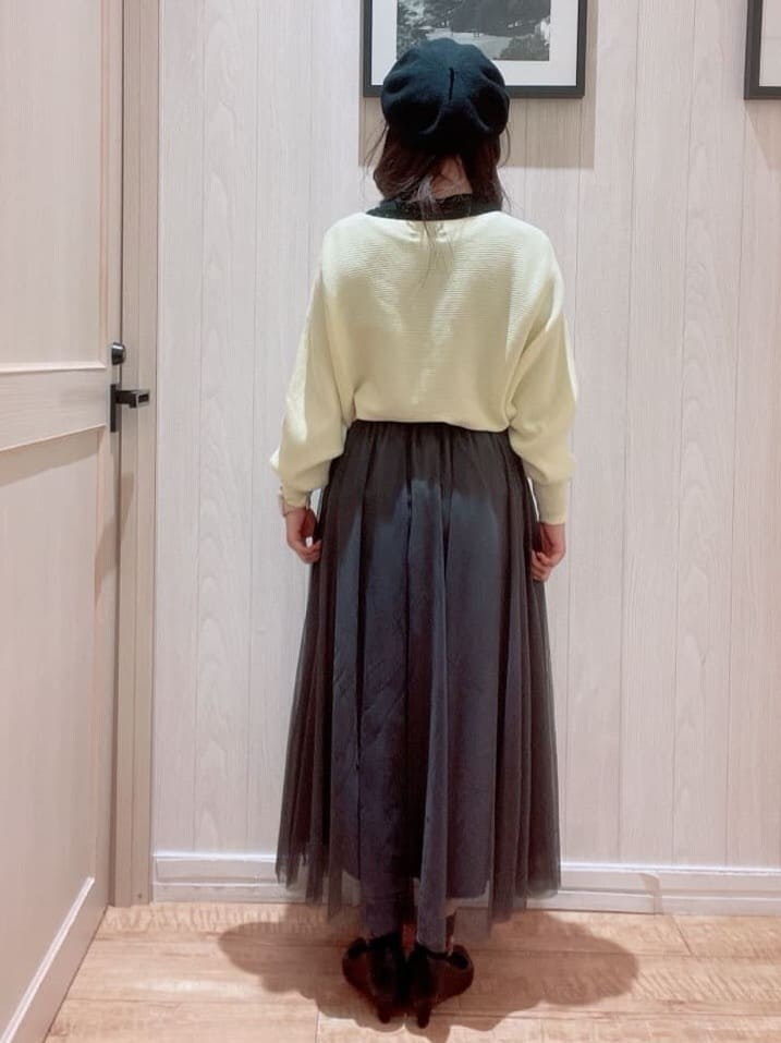イエロー系のニット/セーター、グレー系のスカート、ブラック系のパンプスを着用したレディースの冬コーディネートの3枚目の写真