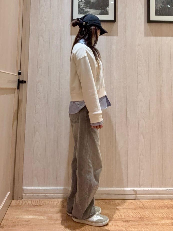 グレー系のデニムパンツ、ホワイト系のスウェット、シルバー系のスニーカーを着用したレディースの春コーディネートの2枚目の写真