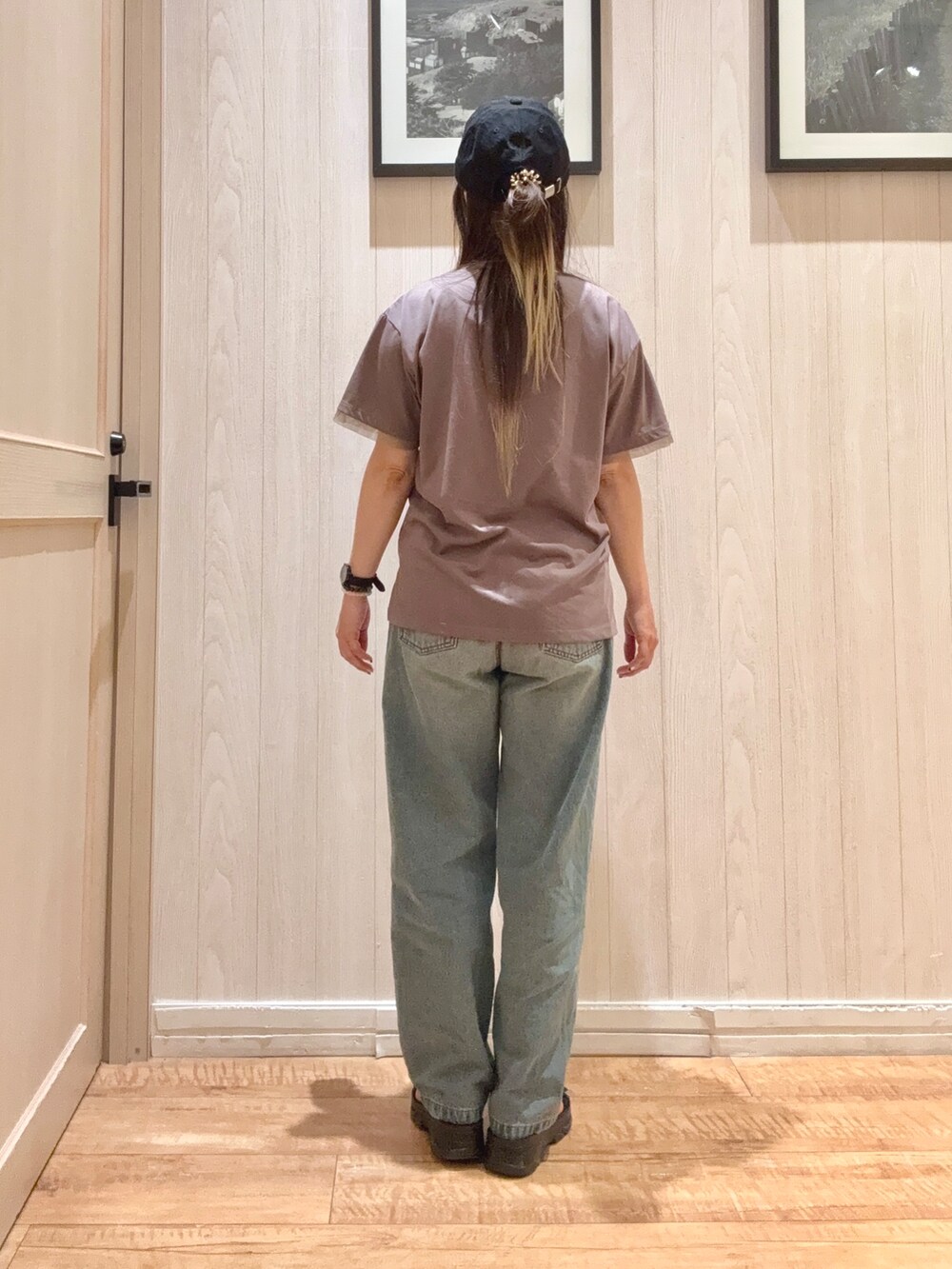 ブラウン系のTシャツ/カットソー、ブルー系のデニムパンツ、ブラック系のサンダルを着用したレディースの春コーディネートの3枚目の写真