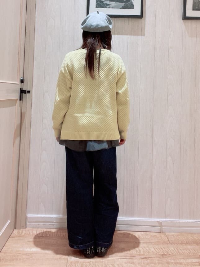 イエロー系のニット/セーター、グレー系のTシャツ/カットソー、ブラック系のショルダーバッグを着用したレディースの冬コーディネートの3枚目の写真