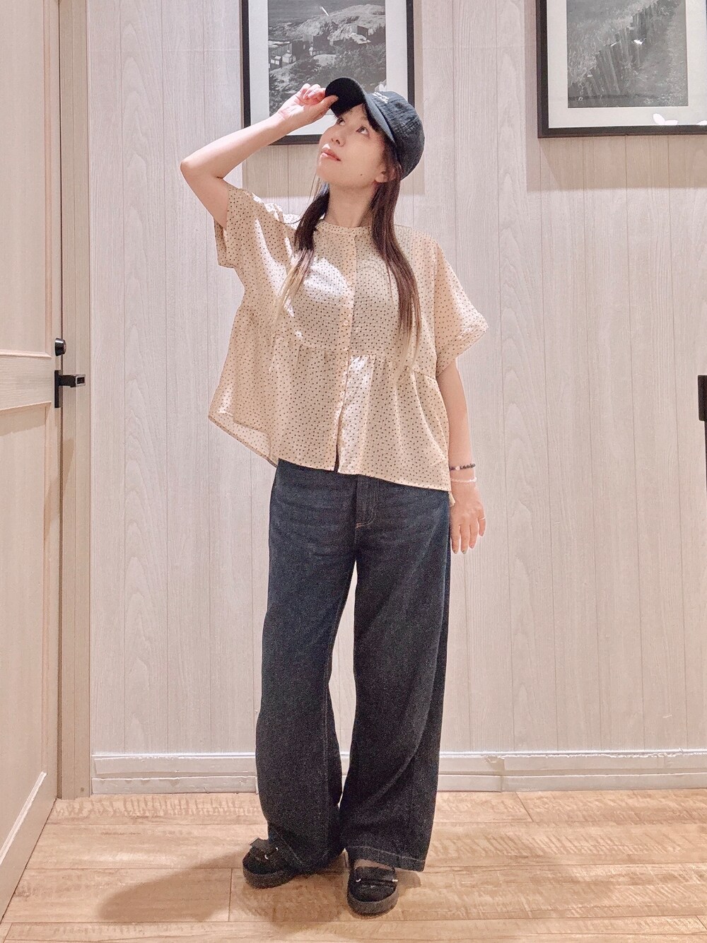 ベージュ系のシャツ/ブラウス、ブルー系のデニムパンツ、ブラック系のキャップを着用したレディースの夏コーディネートの2枚目の写真