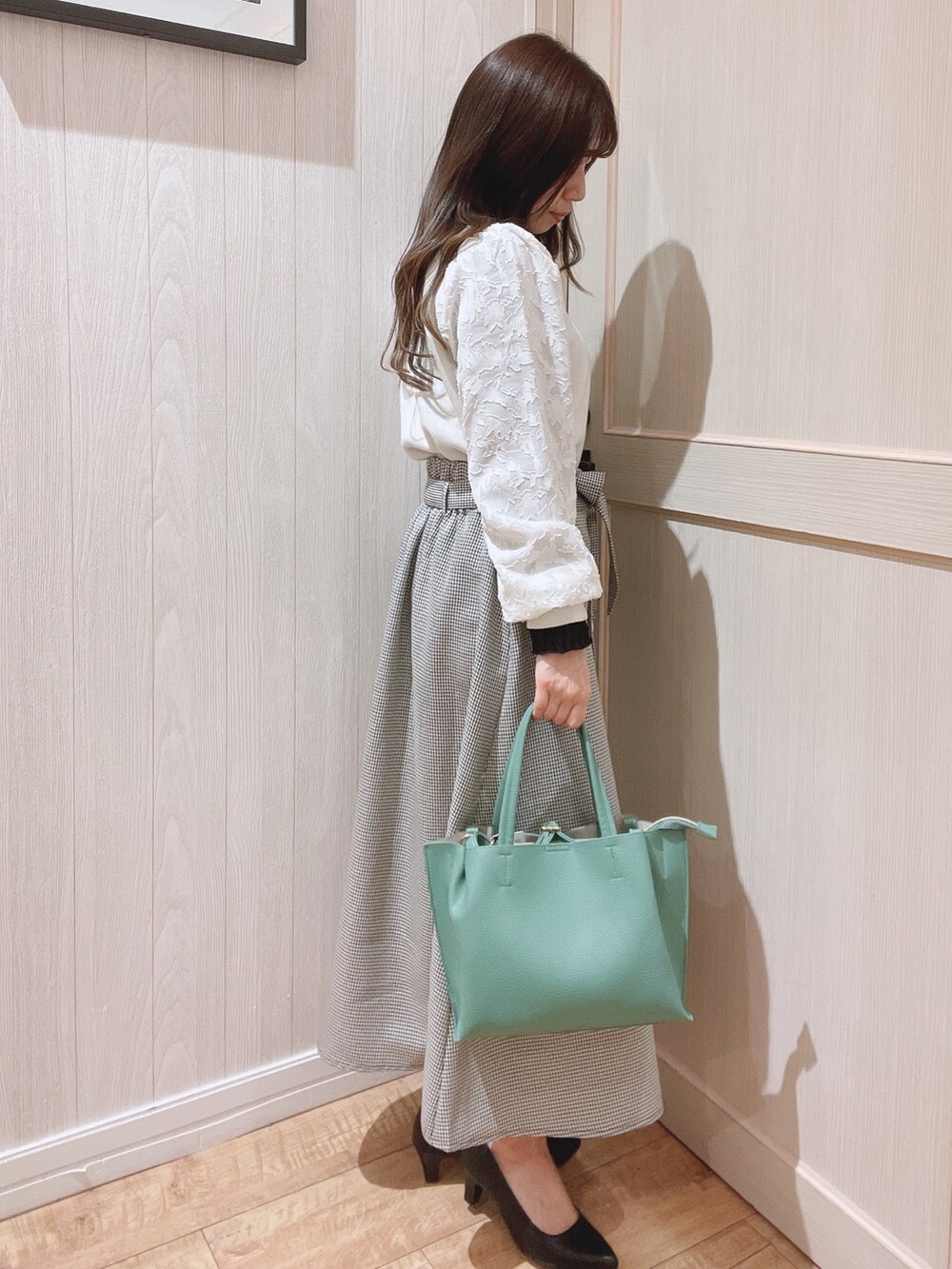 ベージュ系のニット/セーター、ブラウン系のスカート、ブラック系のパンプスを着用したレディースの冬コーディネートの2枚目の写真