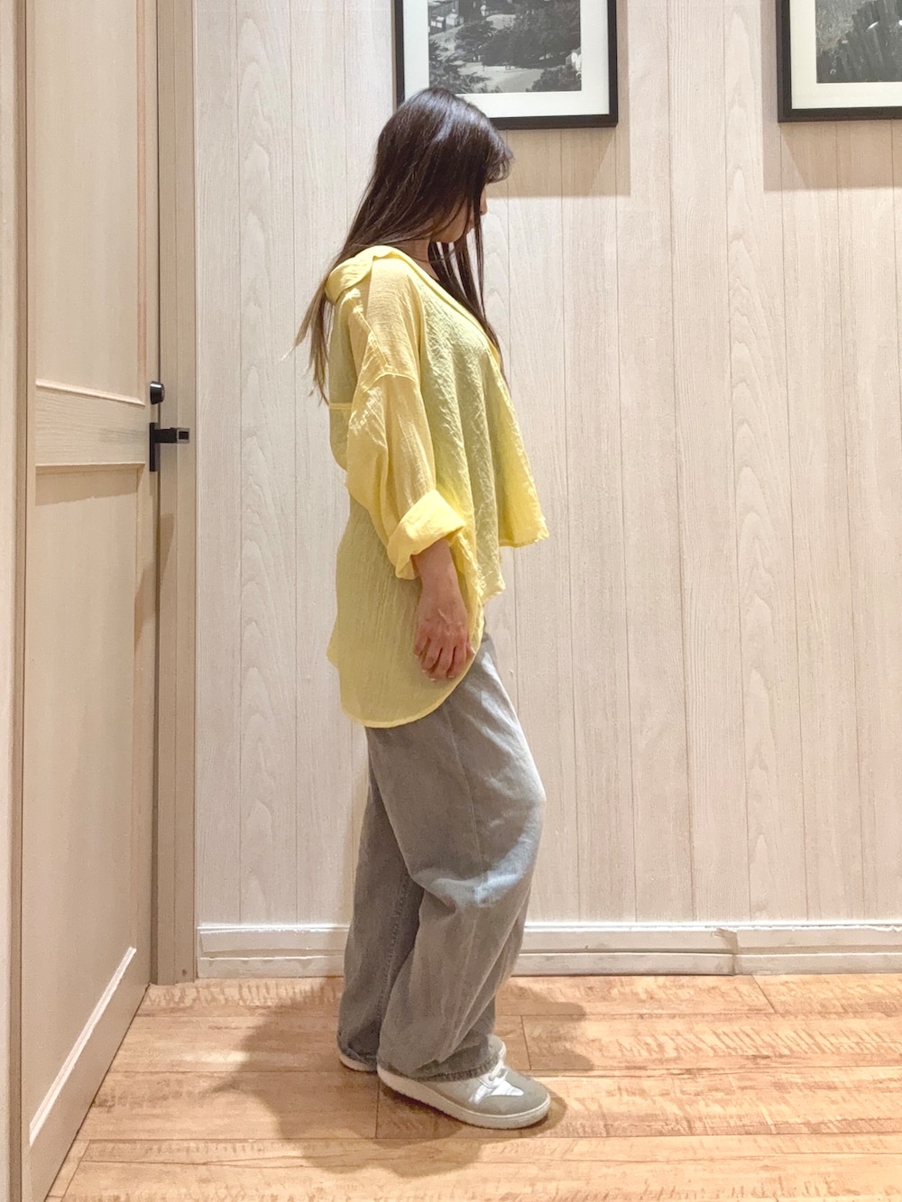 グレー系のデニムパンツ、シルバー系のスニーカー、ブラック系のTシャツ/カットソーを着用したレディースの春コーディネートの2枚目の写真