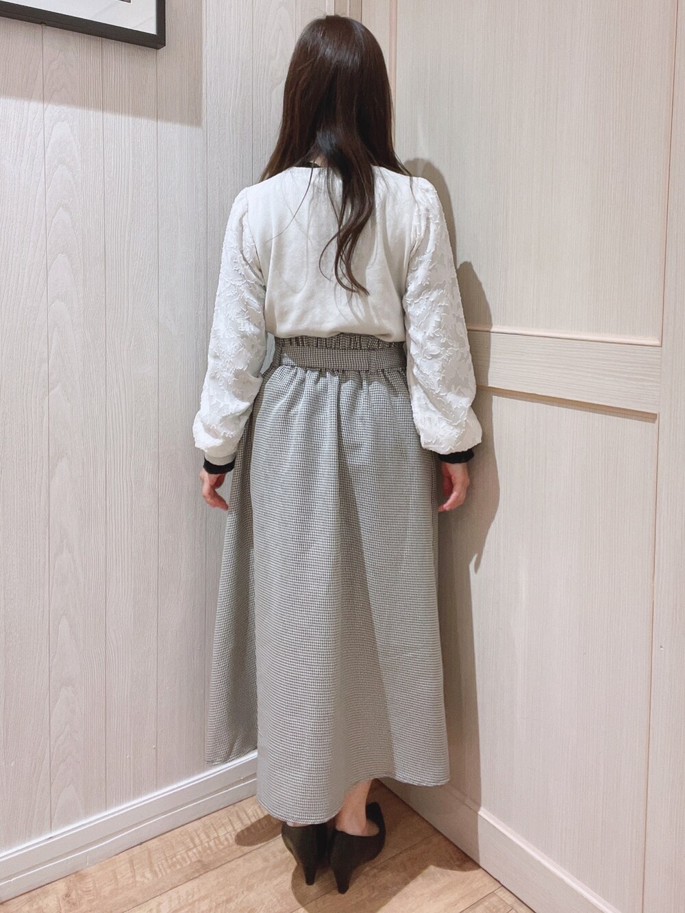 ベージュ系のニット/セーター、ブラウン系のスカート、ブラック系のパンプスを着用したレディースの冬コーディネートの3枚目の写真