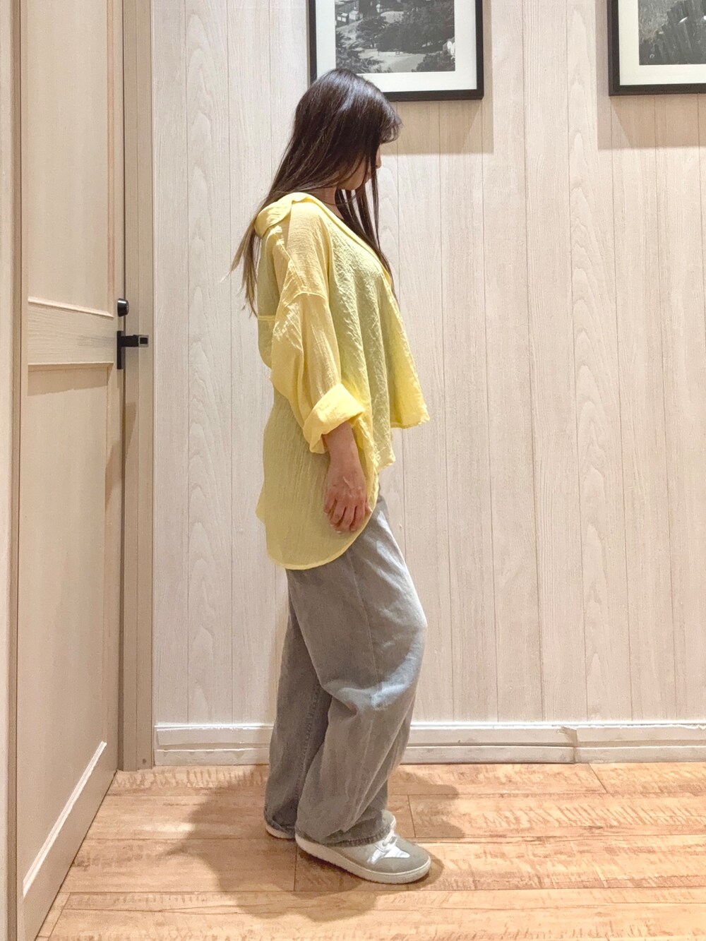 ブラック系のTシャツ/カットソー、イエロー系のシャツ/ブラウス、グレー系のデニムパンツを着用したレディースの春コーディネートの2枚目の写真