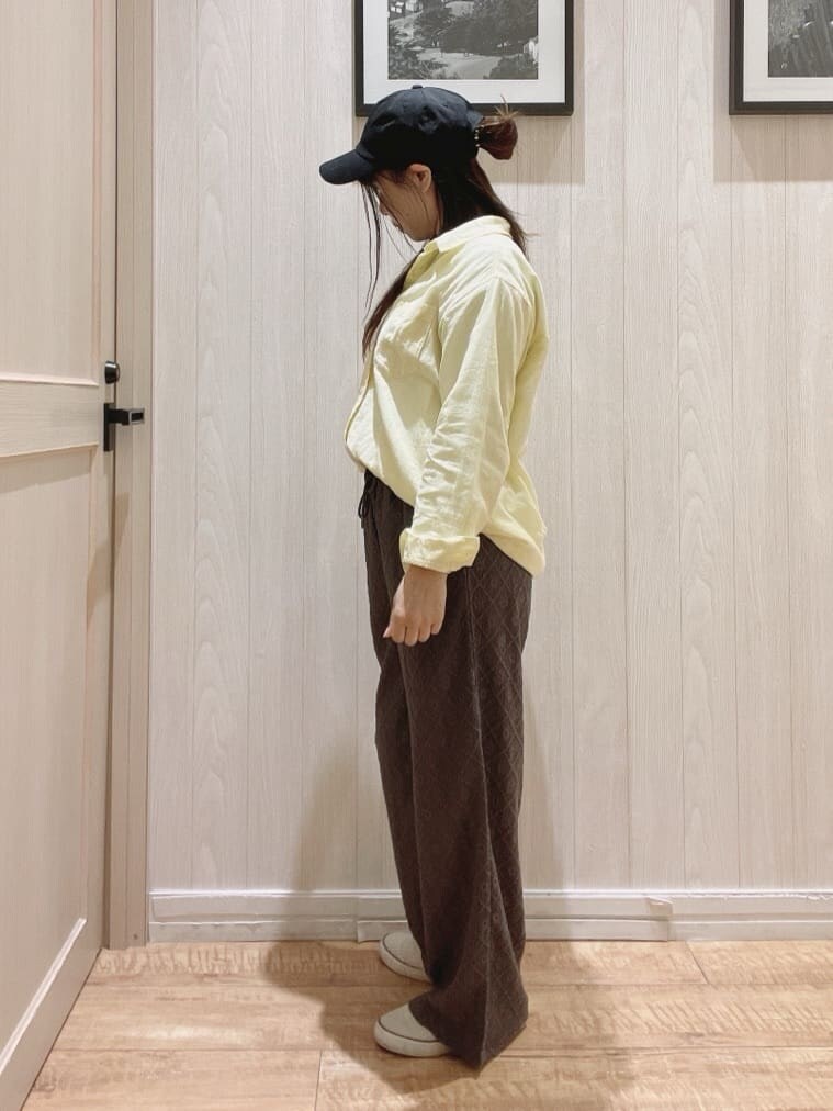 イエロー系のシャツ/ブラウス、ベージュ系のTシャツ/カットソー、グレー系のその他パンツを着用したレディースの春コーディネートの2枚目の写真