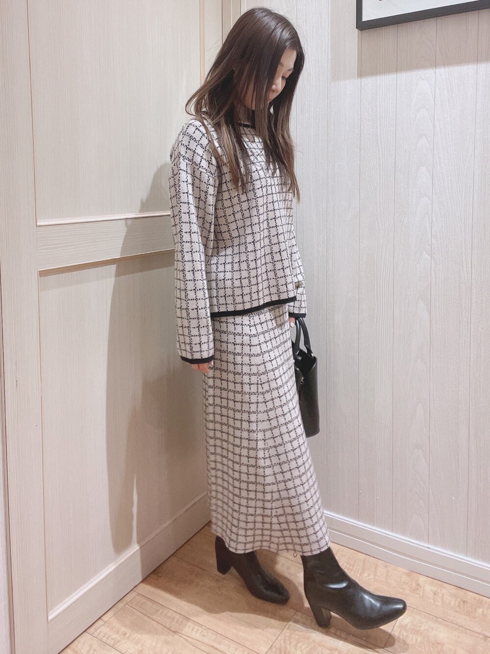 ベージュ系のニット/セーター、ベージュ系のスカート、ブラック系のトートバッグを着用したレディースの冬コーディネートの3枚目の写真