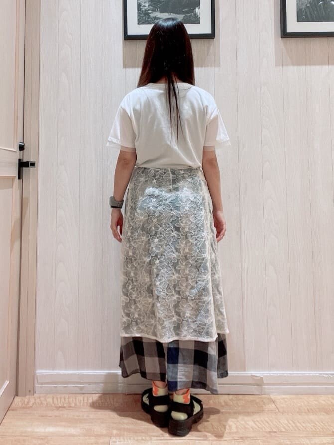 ブルー系のスカート、ホワイト系のスカート、ブラック系のサンダルを着用したレディースの夏コーディネートの3枚目の写真