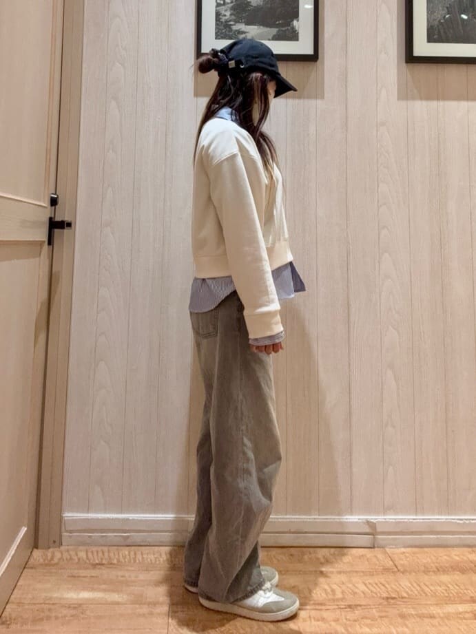 ホワイト系のスウェット、グレー系のデニムパンツ、シルバー系のスニーカーを着用したレディースの春コーディネートの2枚目の写真