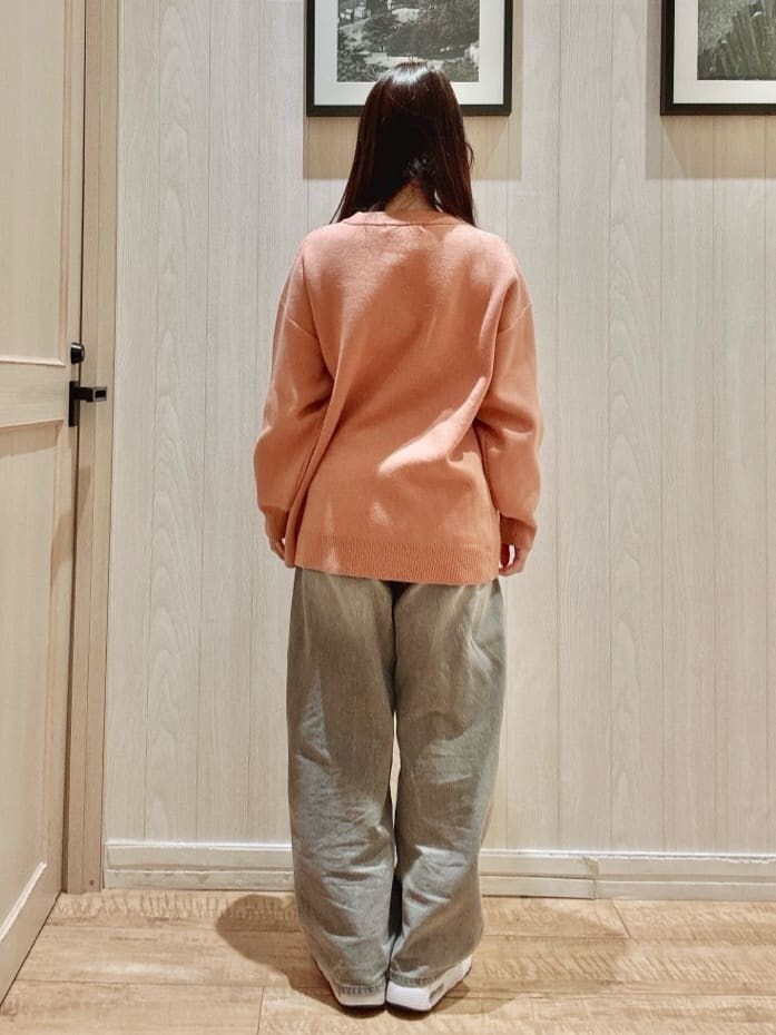オレンジ系のニット/セーター、グレー系のデニムパンツを着用したレディースの冬コーディネートの3枚目の写真