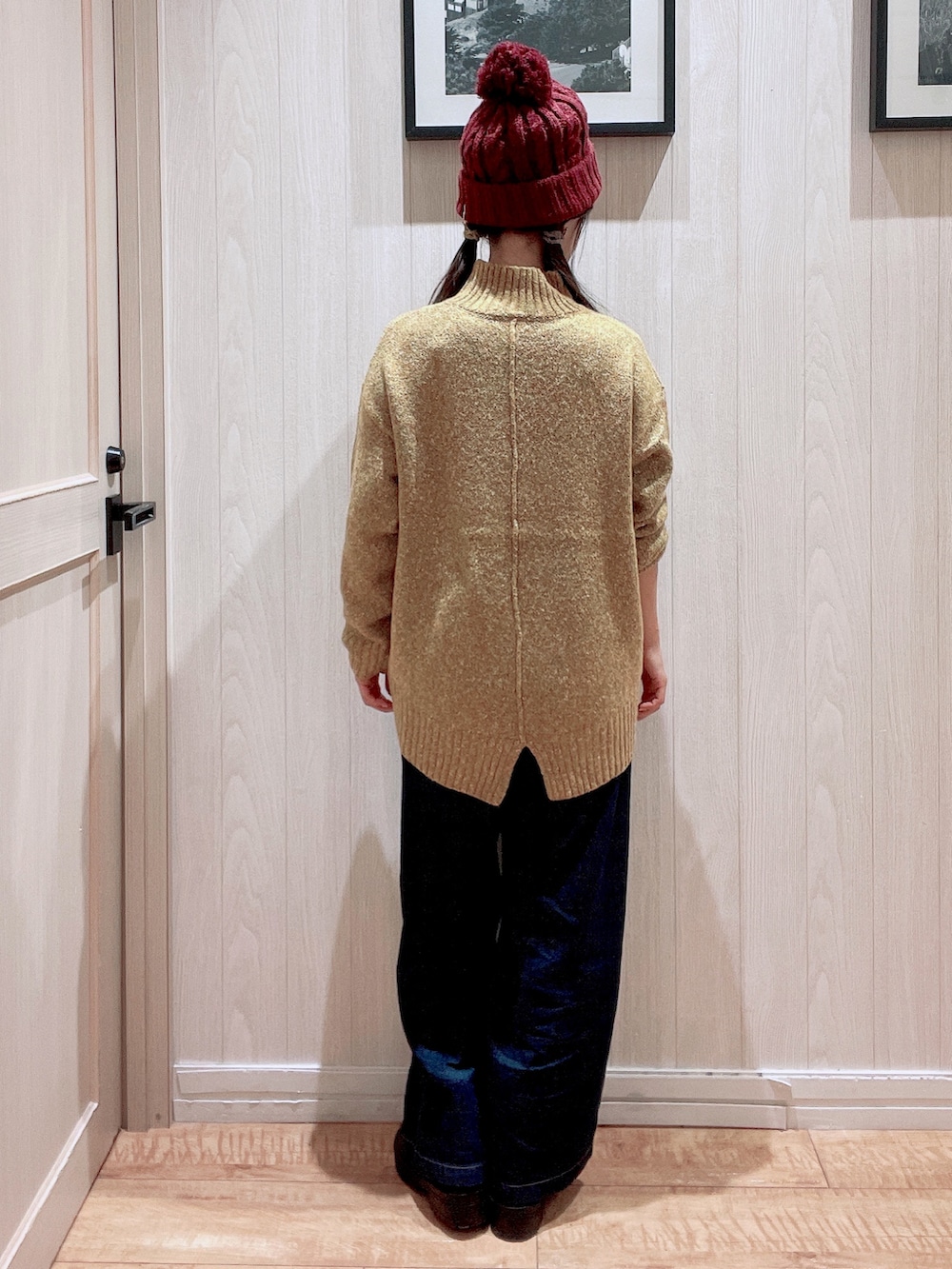 イエロー系のニット/セーター、ブラック系のブーツ、ブルー系のデニムパンツを着用したレディースの秋コーディネートの3枚目の写真