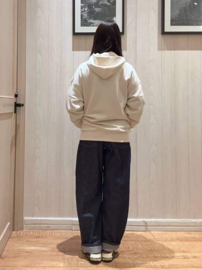 ホワイト系のパーカー、ブルー系のデニムパンツを着用したレディースの冬コーディネートの2枚目の写真
