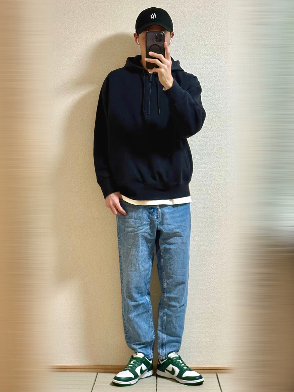 グリーン系のスニーカー、ブルー系のデニムパンツ、ブラック系のブルゾンを着用したメンズの冬コーディネートの3枚目の写真