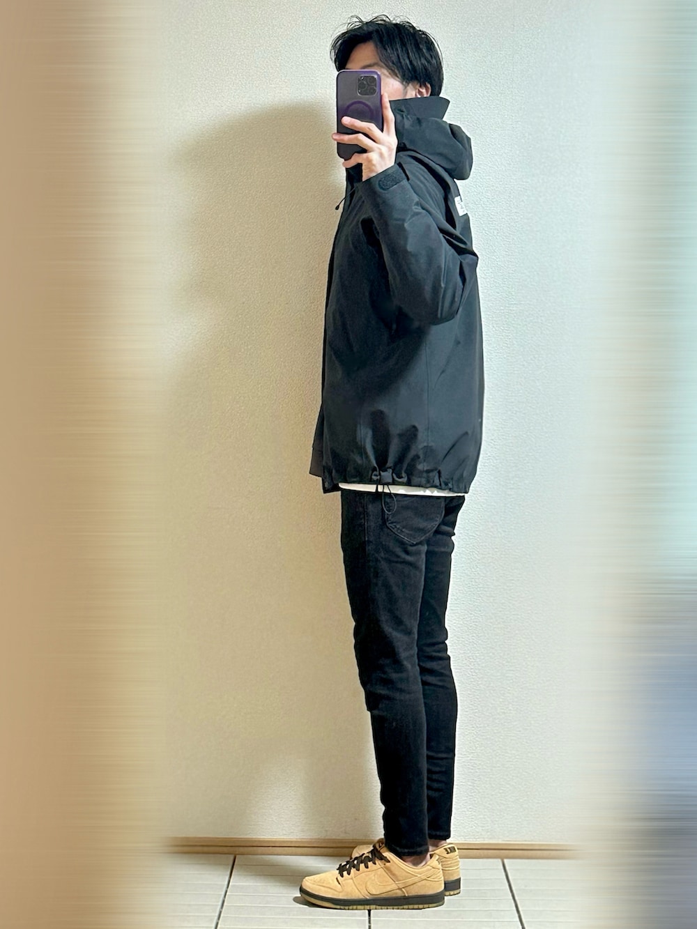 ブラウン系のスニーカー、ブラック系のデニムパンツ、ブラック系のブルゾンを着用したメンズの冬コーディネートの3枚目の写真