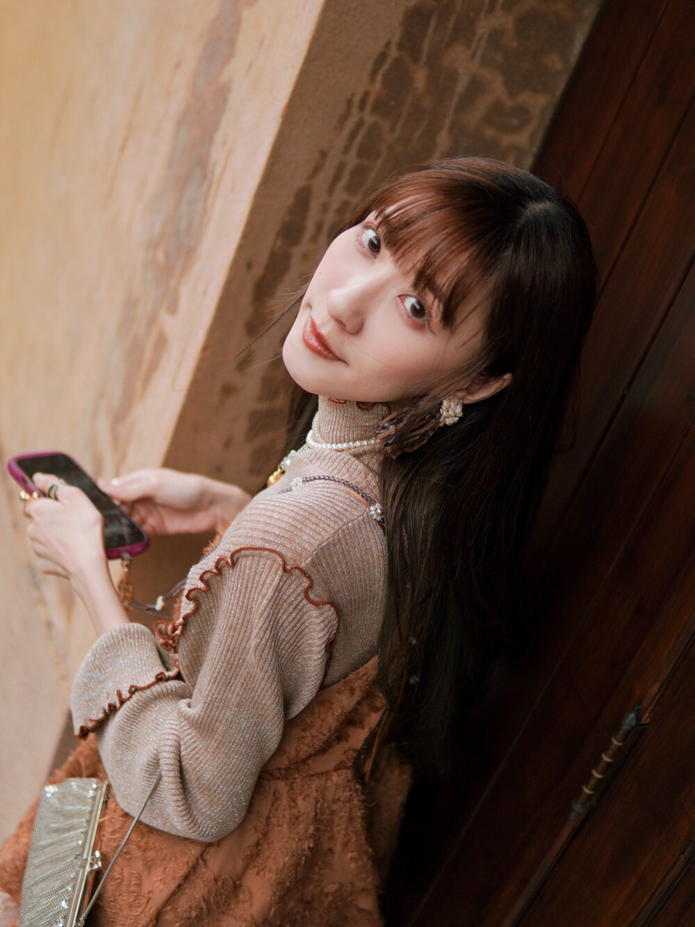 ホワイト系のシューズ、オレンジ系のトップス、ベージュ系のトップスを着用したレディースの冬コーディネートの5枚目の写真