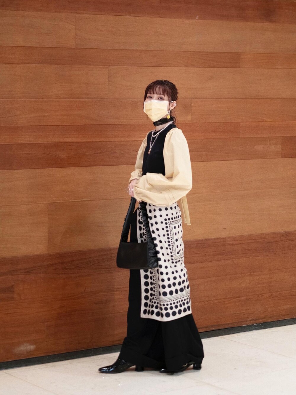 ブラック系のTシャツ/カットソー、イエロー系のカーディガン/ボレロ、ブラック系のハンドバッグを着用したレディースの夏コーディネートの4枚目の写真