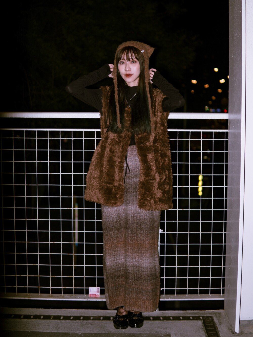 ブラウン系のスカート、ブラウン系のベスト、ブラック系のシューズを着用したレディースの冬コーディネートの2枚目の写真