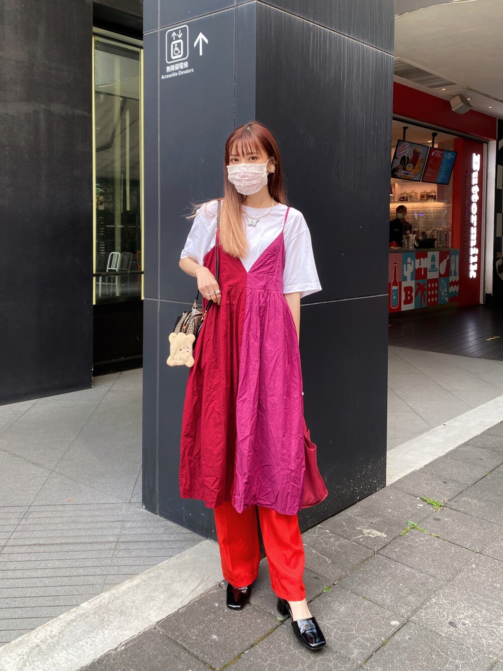 ブラック系のパンプス、レッド系のパンツ、ホワイト系のTシャツ/カットソーを着用したレディースの夏コーディネートの2枚目の写真