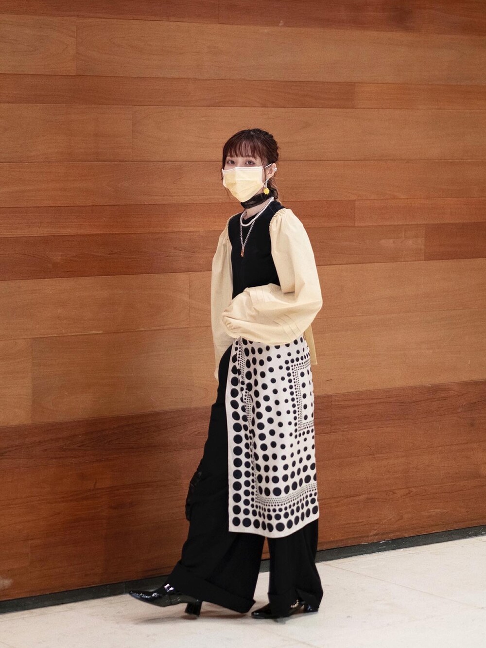 ブラック系のTシャツ/カットソー、イエロー系のカーディガン/ボレロ、ブラック系のハンドバッグを着用したレディースの夏コーディネートの2枚目の写真