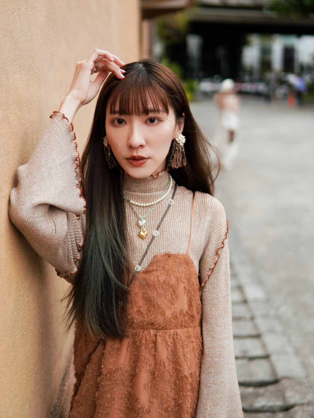 ホワイト系のシューズ、オレンジ系のトップス、ベージュ系のトップスを着用したレディースの冬コーディネートの3枚目の写真