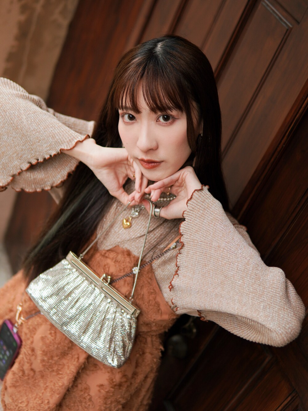 ホワイト系のシューズ、オレンジ系のトップス、ベージュ系のトップスを着用したレディースの冬コーディネートの4枚目の写真