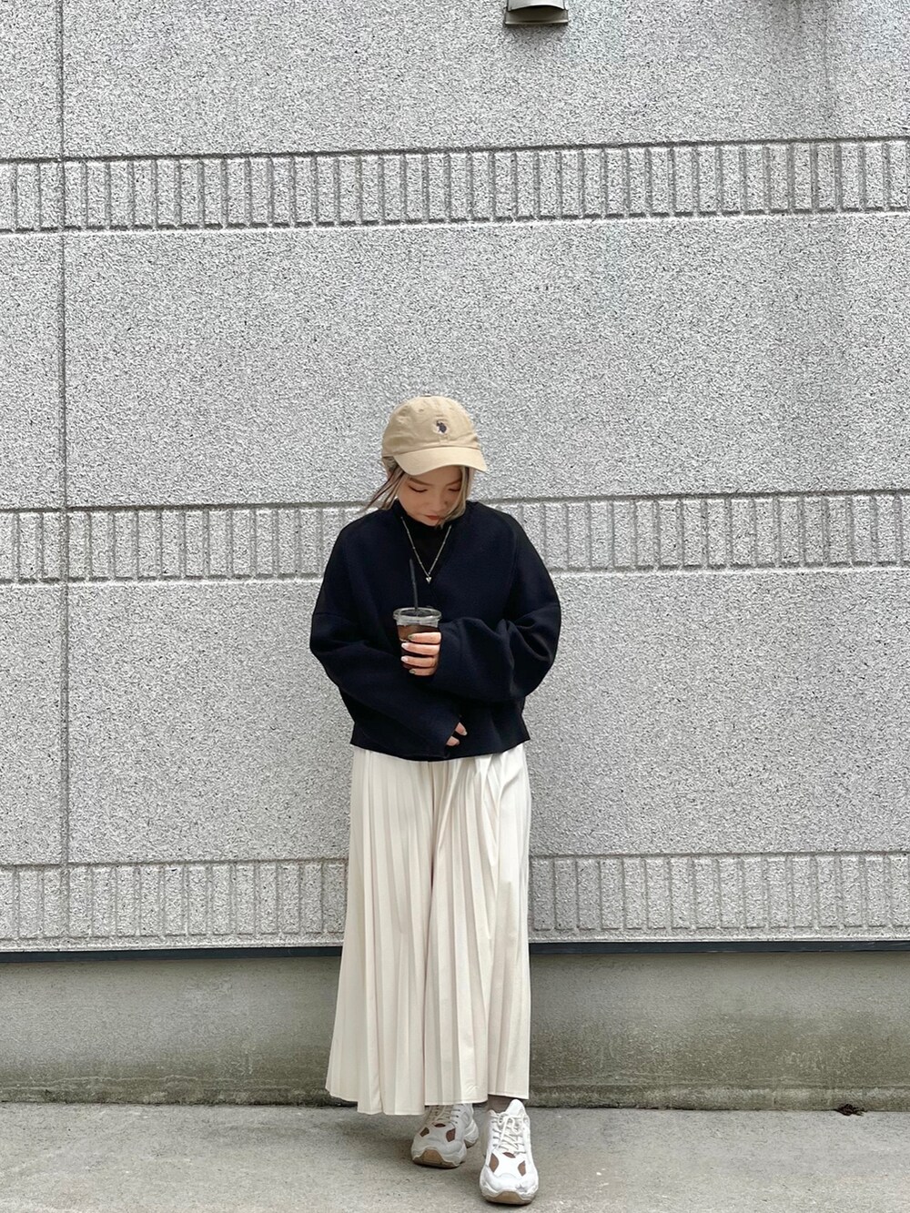 ブラック系のカーディガン/ボレロ、ベージュ系のスカートを着用したレディースの春コーディネートの2枚目の写真