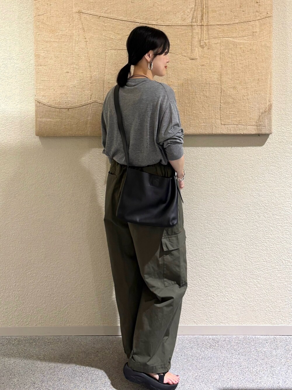 グレー系のニット/セーター、グリーン系のその他パンツを着用したレディースの夏コーディネートの3枚目の写真