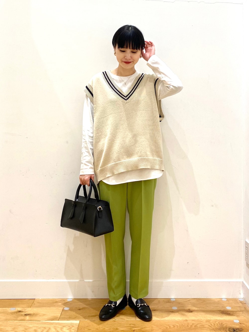 ベージュ系のニット/セーター、グリーン系のその他パンツ、ブラック系のトートバッグを着用したレディースの冬コーディネートの3枚目の写真
