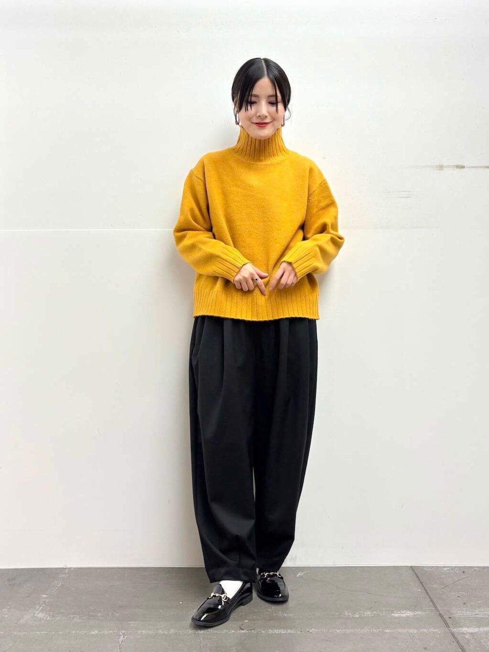ブラック系のローファー、イエロー系のニット/セーター、ブラック系のその他パンツを着用したレディースの冬コーディネートの5枚目の写真