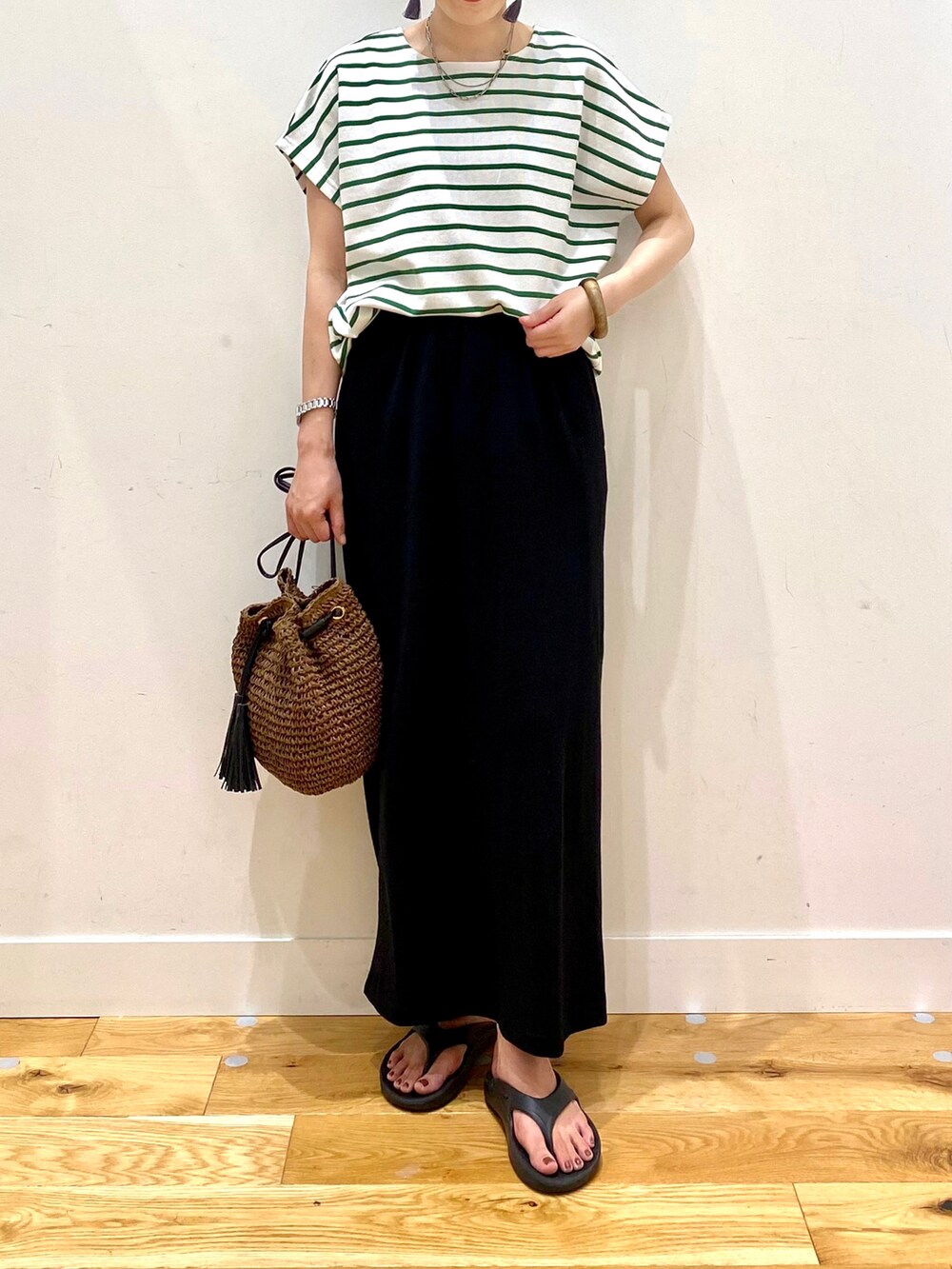 グリーン系のTシャツ/カットソー、ブラック系のスカート、ブラウン系のショルダーバッグを着用したレディースの夏コーディネートの4枚目の写真