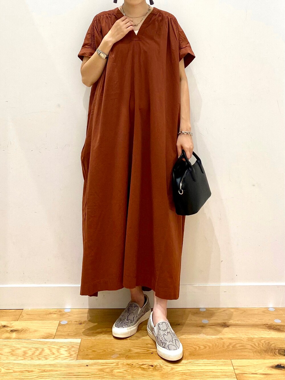 レッド系のワンピース、ブラック系のショルダーバッグ、ベージュ系のハットを着用したレディースの夏コーディネートの4枚目の写真