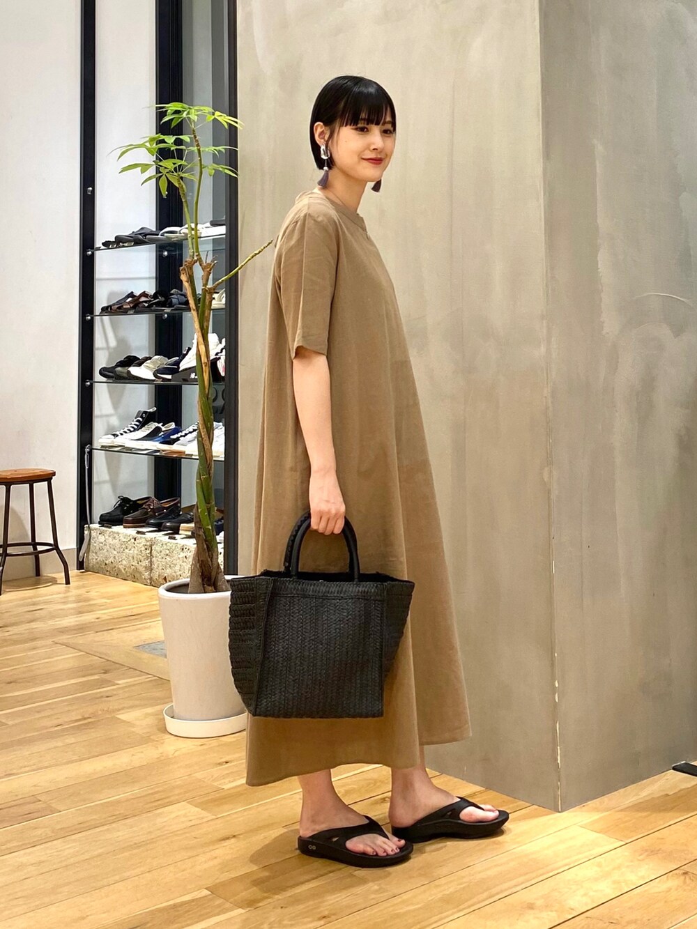 ベージュ系のワンピース、ブラック系のトートバッグ、ブラック系のサンダルを着用したレディースの春コーディネートの3枚目の写真