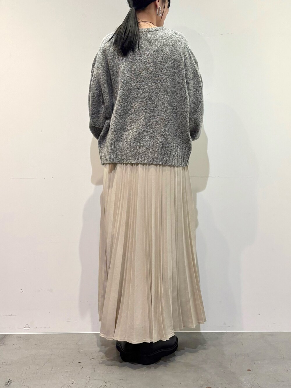 グレー系のニット/セーター、ホワイト系のスカート、ブラック系のローファーを着用したレディースの冬コーディネートの5枚目の写真