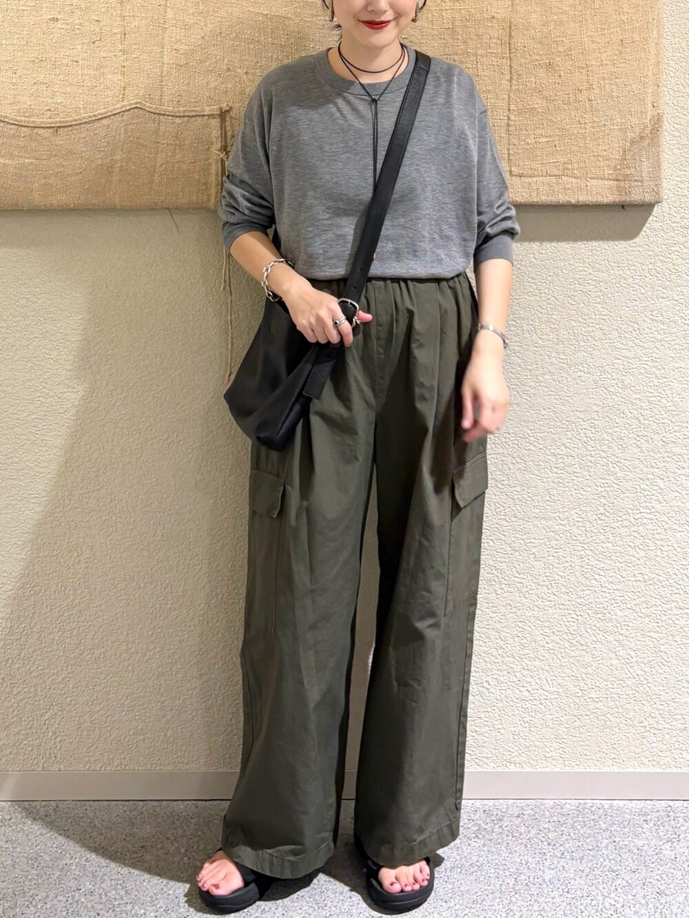 グレー系のニット/セーター、グリーン系のその他パンツを着用したレディースの夏コーディネートの4枚目の写真