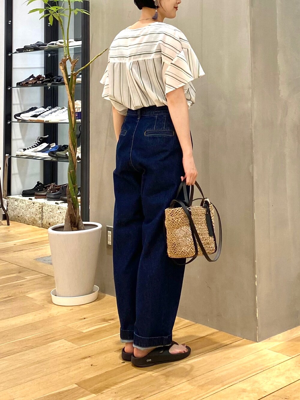 グリーン系のシャツ/ブラウス、ブルー系のデニムパンツ、ブラック系のサンダルを着用したレディースの春コーディネートの5枚目の写真
