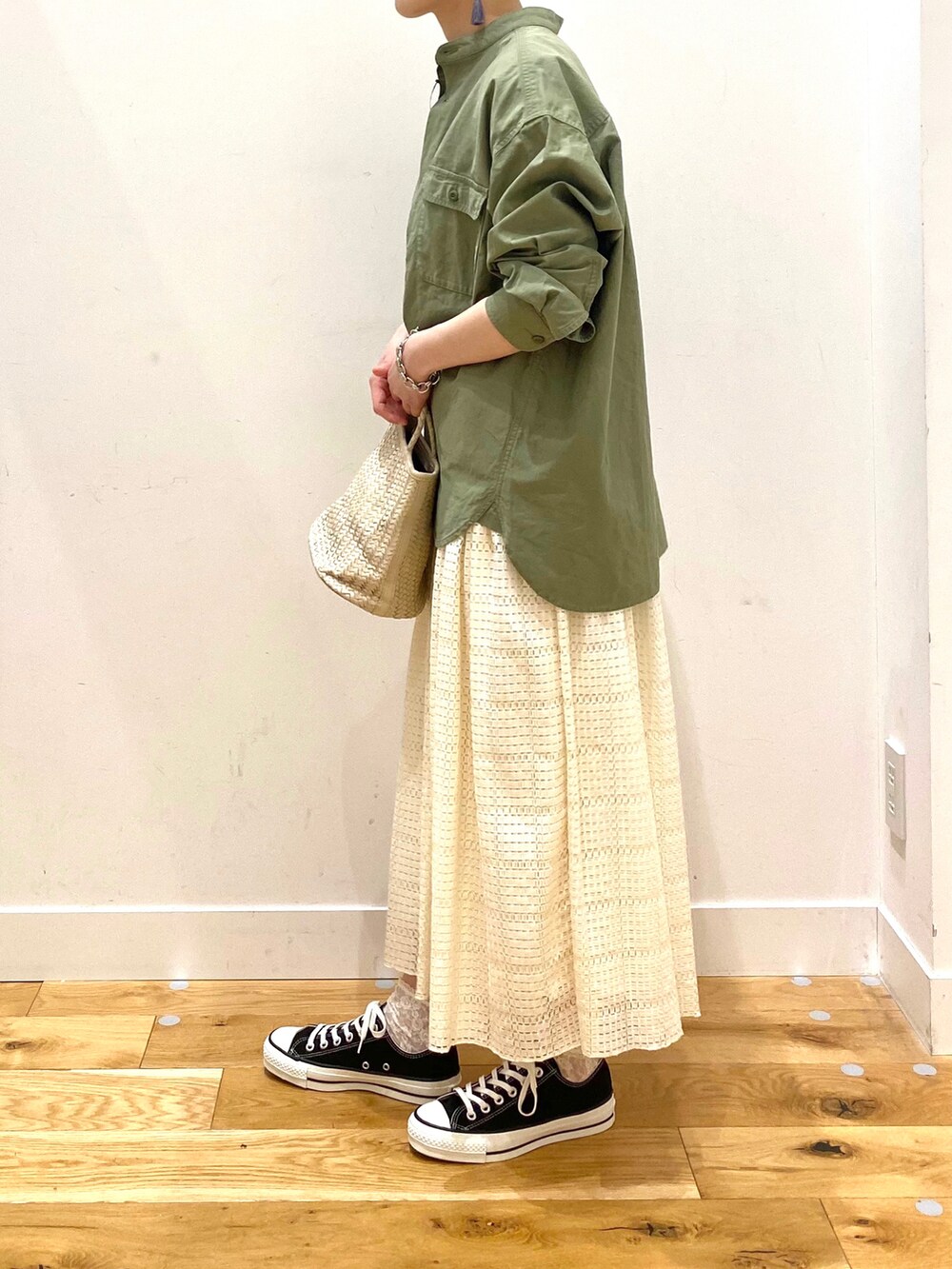 グリーン系のシャツ/ブラウス、ホワイト系のスカート、ブラック系のスニーカーを着用したレディースの春コーディネートの5枚目の写真