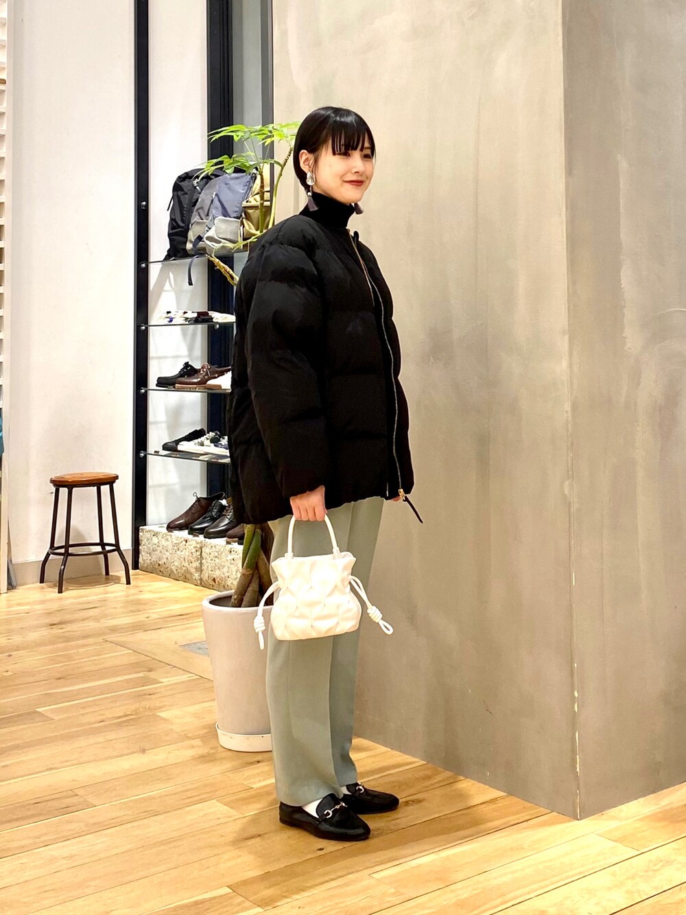 ブラック系のダウンジャケット/コート、ブラック系のニット/セーター、グリーン系のその他パンツを着用したレディースの冬コーディネートの2枚目の写真