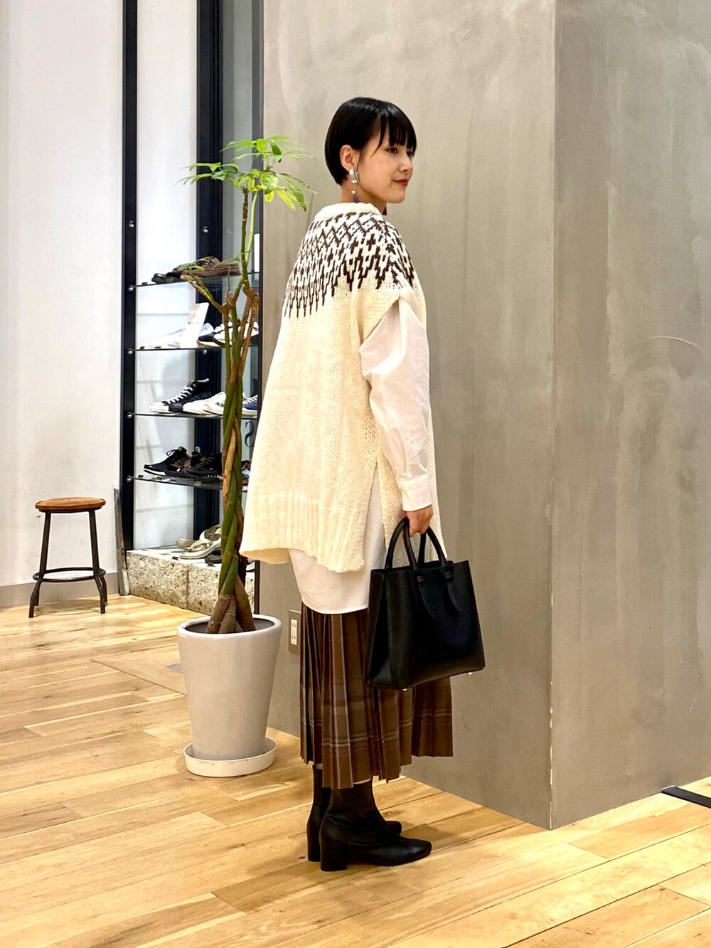 ホワイト系のニット/セーター、ホワイト系のシャツ/ブラウス、ブラウン系のスカートを着用したレディースの秋コーディネートの2枚目の写真