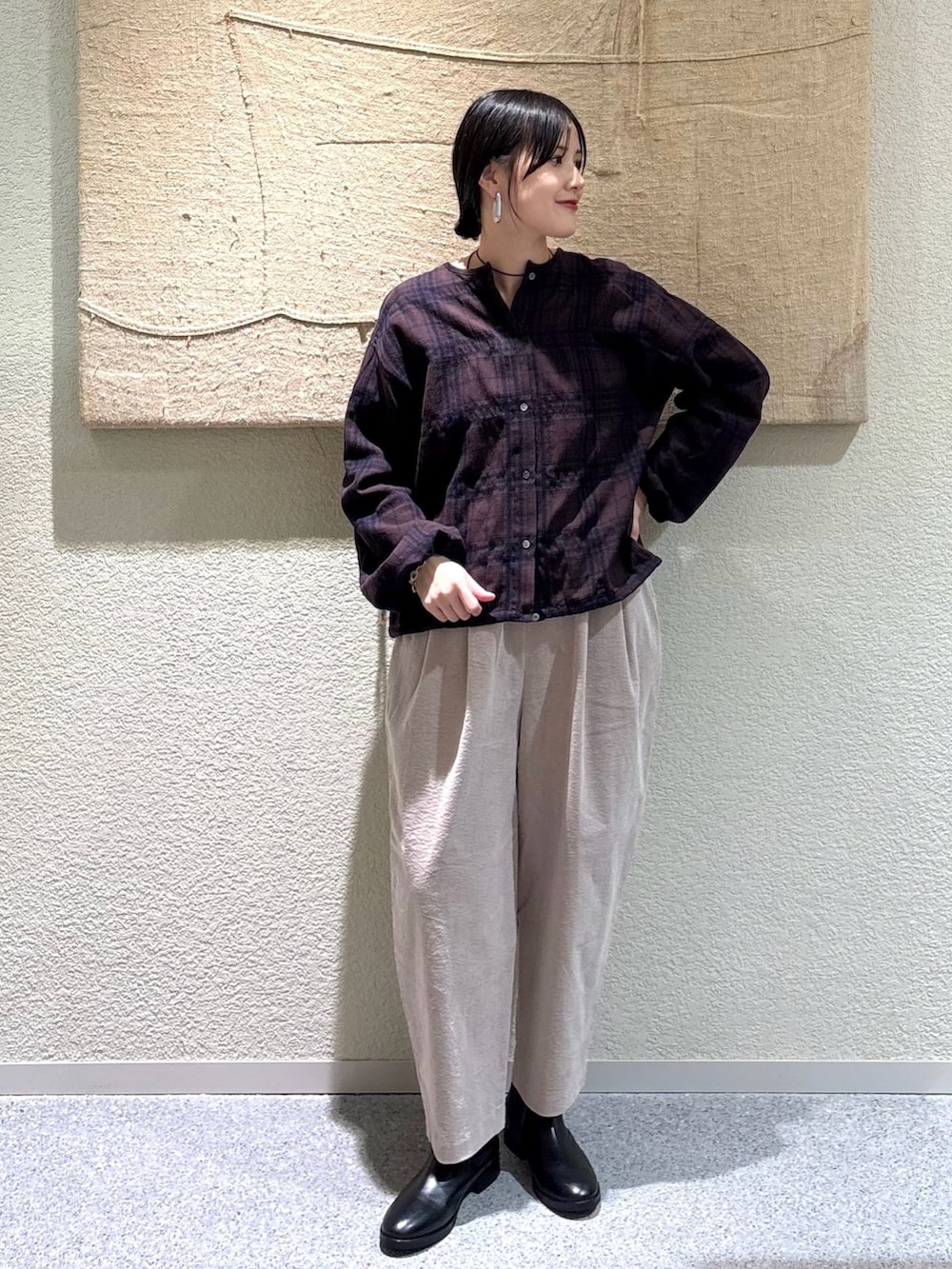 ブラウン系のカーディガン/ボレロ、グレー系のその他パンツ、ブラック系のブーツを着用したレディースの秋コーディネートの6枚目の写真