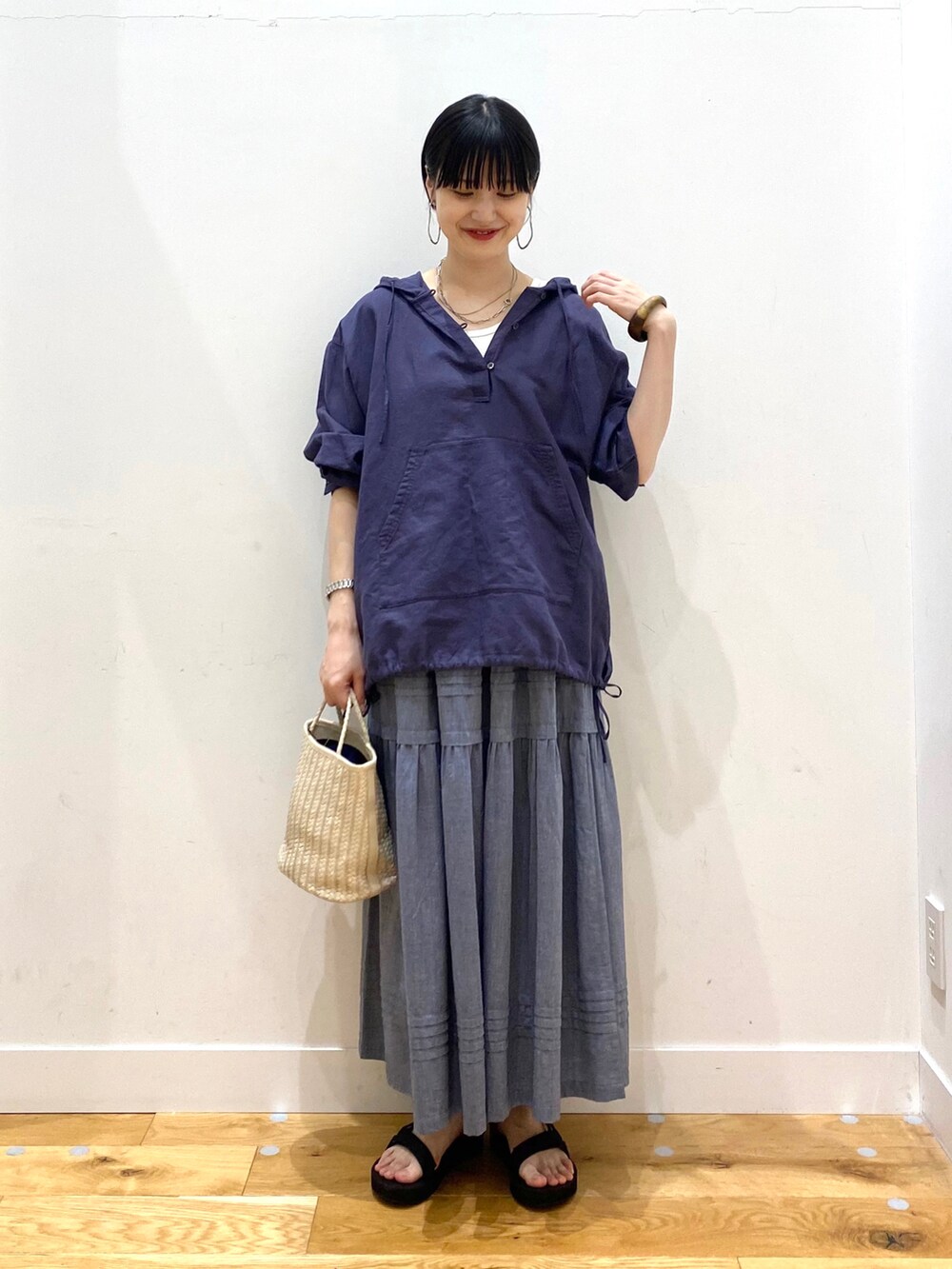 ブルー系のパーカー、ホワイト系のタンクトップ、グレー系のスカートを着用したレディースの春コーディネートの2枚目の写真