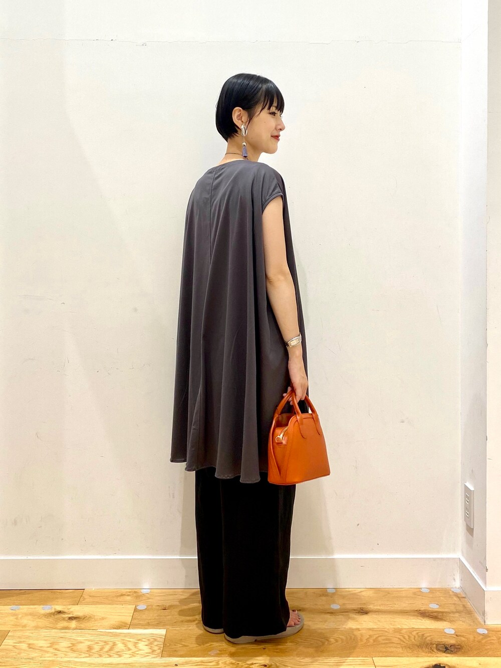 グレー系のTシャツ/カットソー、ブラック系のその他パンツ、オレンジ系のショルダーバッグを着用したレディースの夏コーディネートの3枚目の写真