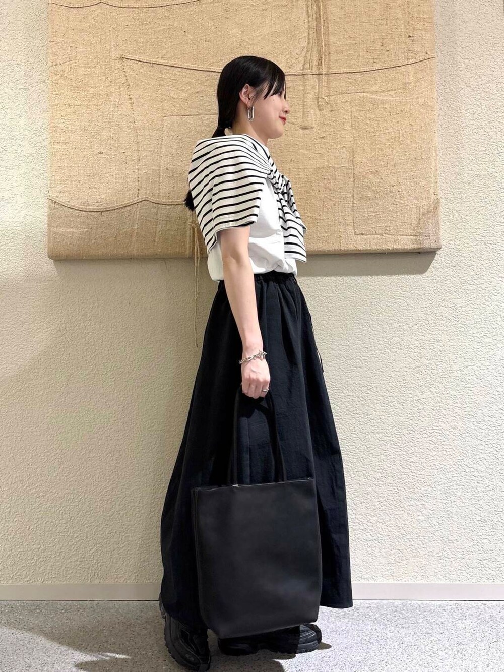 ブラック系のTシャツ/カットソーを着用したレディースの春コーディネートの3枚目の写真