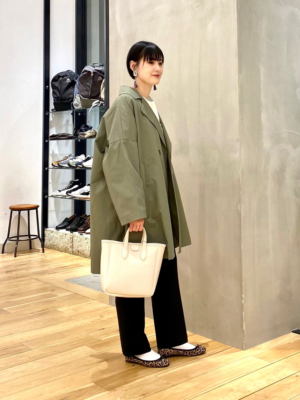 グリーン系のポンチョ、ホワイト系のスウェット、その他のバレエシューズを着用したレディースの春コーディネートの2枚目の写真